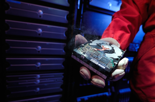Firefighter holding smoking computer hard drive