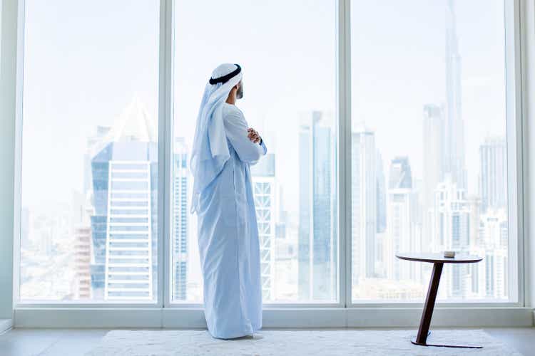 Side view of arabic businessman looking through window in modern office
