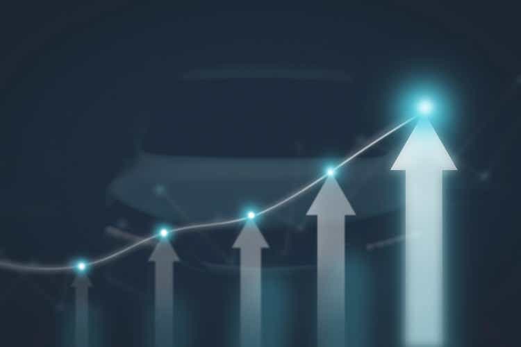 The arrow graph automotive future growth plan with glowing points and vehicle blurred on background