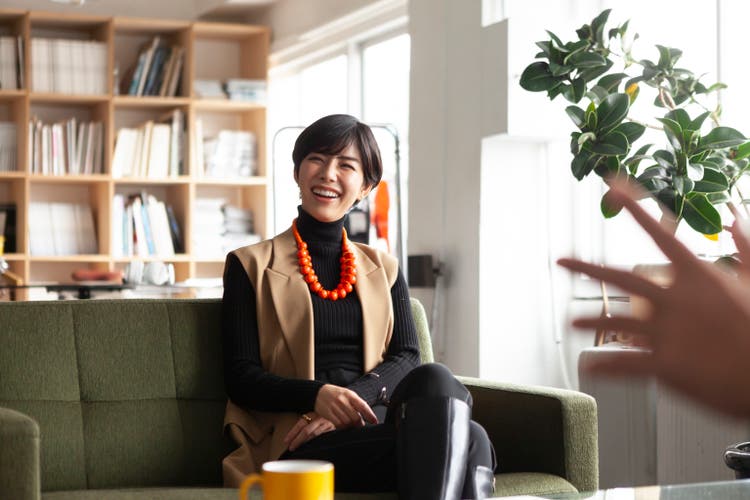 Young businesswoman chatting with colleagues in a creative office.