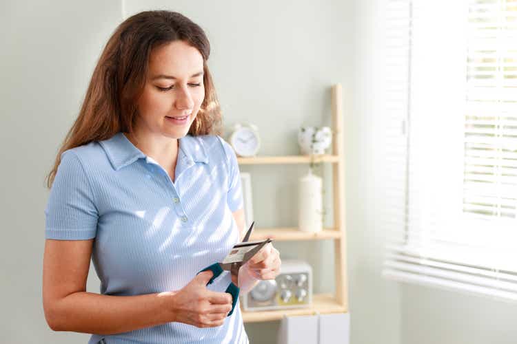 Young woman cutting a credit card with scissors