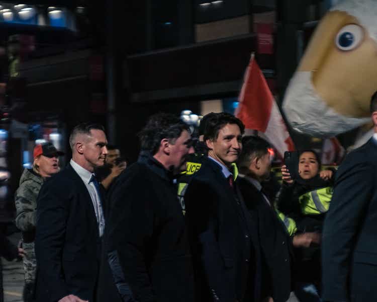 Canadian Prime Minister Justin Trudeau walking across the street through Protestors