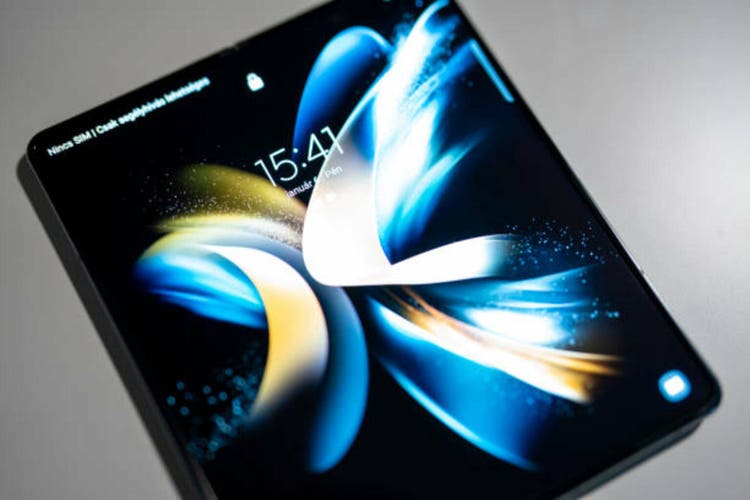 Brand new Samsung Galaxy Z Fold 4 in grey-green color. Close up of new smartphone with foldable screen opened. White background.