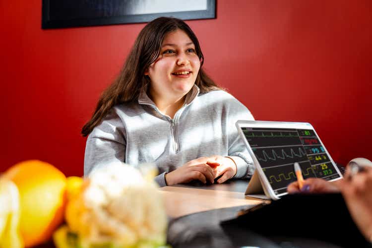 teenager patient indoors in the office listening the nutritionist