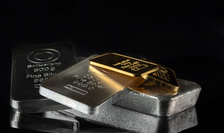 Gold and silver bars of various weights on a dark background.