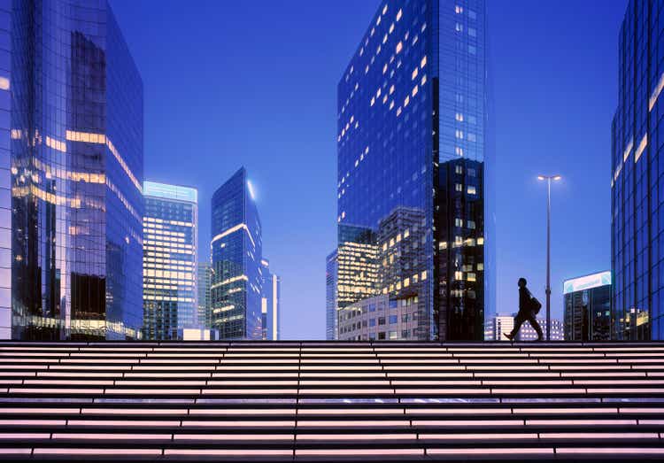 Businessmen arriving at modern business district at dawn