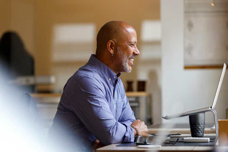 Happy businessman doing video call through laptop at office