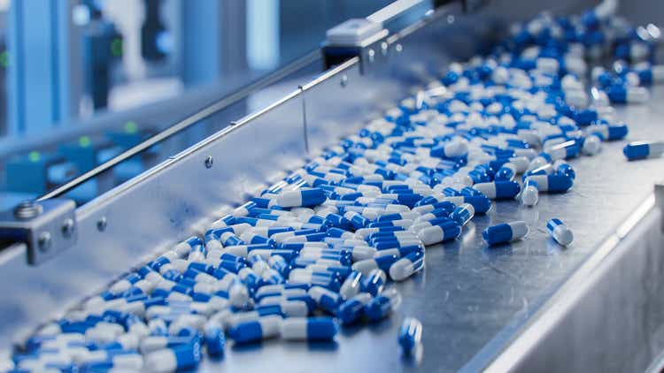 Blue Capsules on Conveyor at Modern Pharmaceutical Factory. Tablet and Capsule Manufacturing Process. Close-up Shot of Medical Drug Production Line.