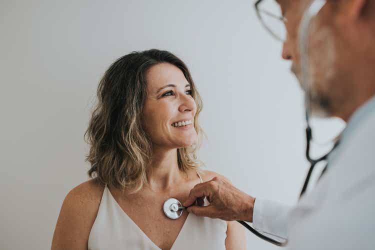 Doctor listening to patient"s heart with stethoscope