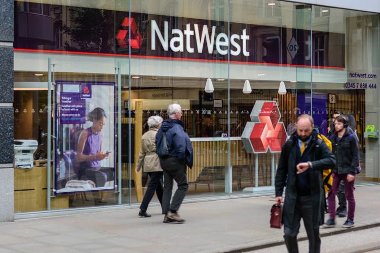 A high street branch of Natwest bank, with people and customers walking past.