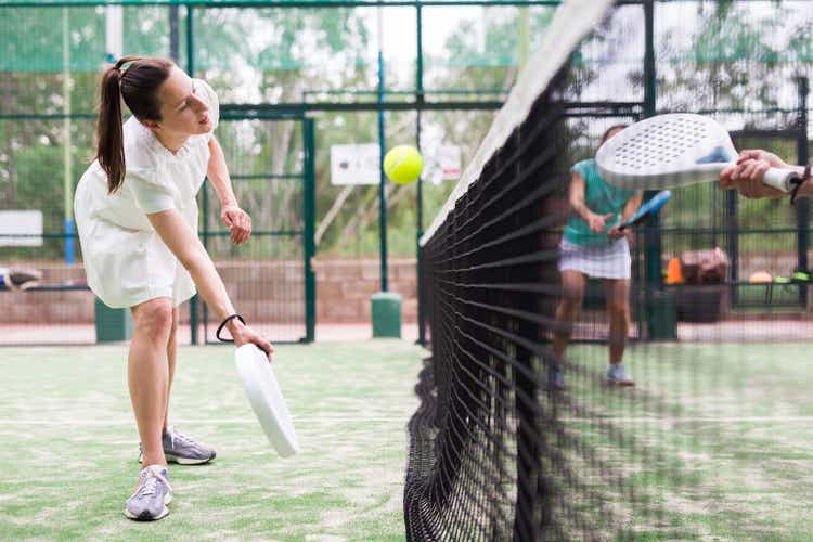 Young emotional women playing paddle tennis outdoors