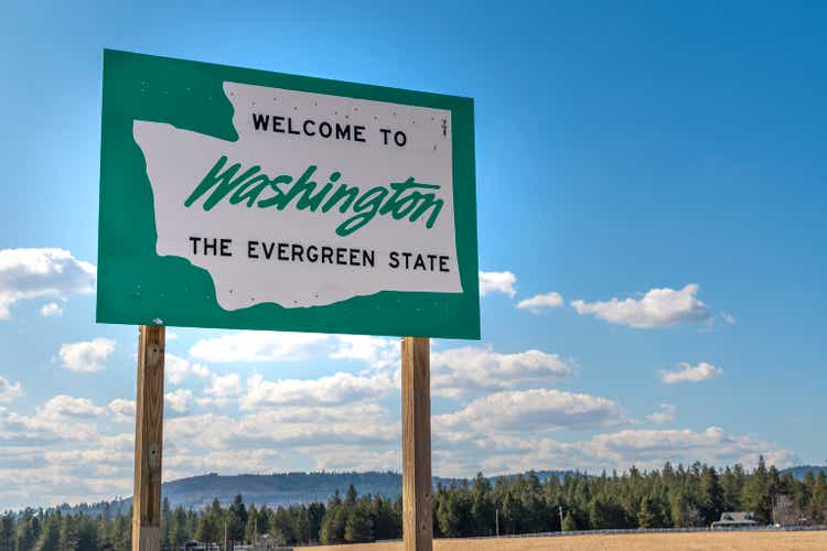 A roadside welcome to Washington the Evergreen State sign in the rural area near Spokane, Washington, USA, coming from the state of Idaho.
