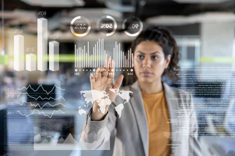 Business woman looking at the market data on an interactive screen