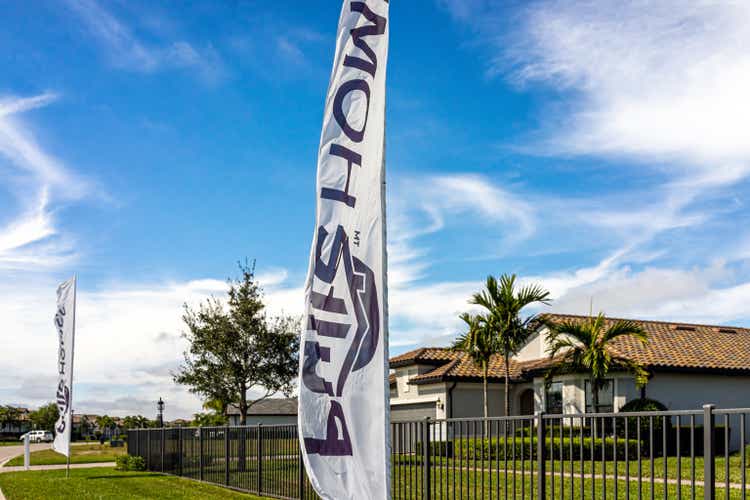 Residential house home community built by Pulte PulteGroup real estate developer with sign banner flags outdoors near Naples, Florida