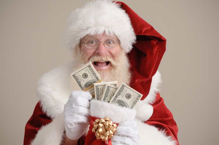 Santa holding a stocking filled with money