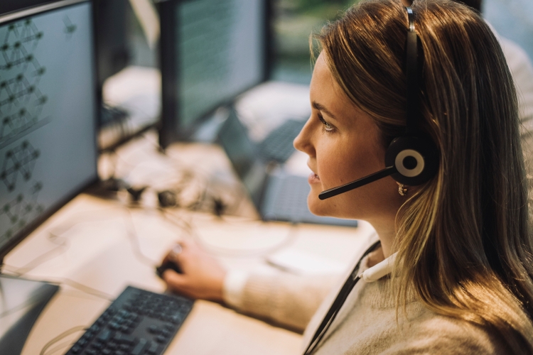 Side view of female customer service representative talking through headset at call center