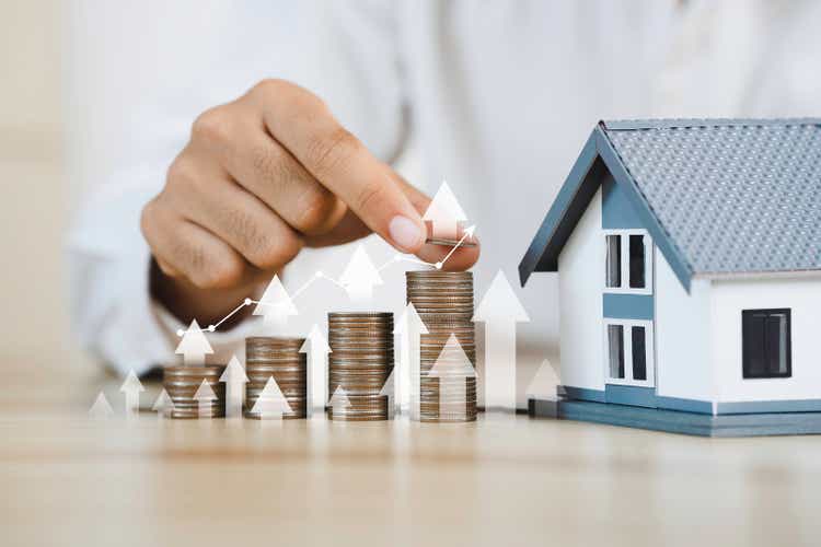 House model and coin holder money on the table for finance and banking concepts. Property investment mortgage and home rental concept earning from home