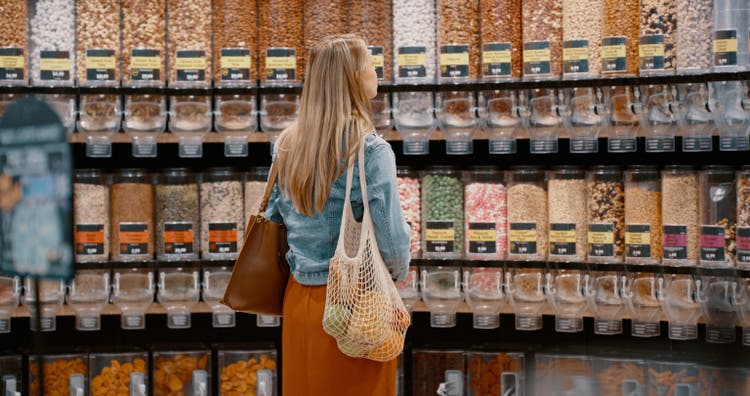 Woman, choice or grocery shopping for nuts, seeds or health food products in retail sales store. Thinking, customer or consumer in organic supermarket for trail mix, vegan snack or wellness groceries