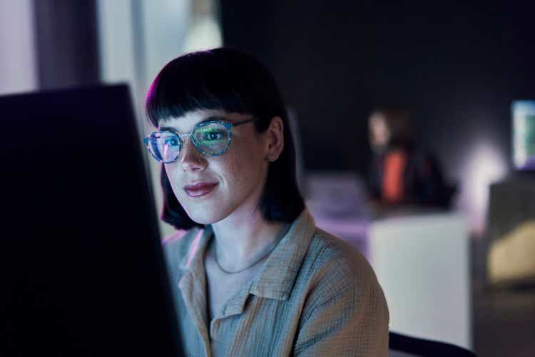 Business woman, computer seo work and coding of young employee with crypto and glasses. Digital code, female face and reading of a it employee at night planning with online hacker and ai data