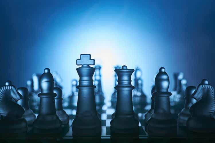 Transparent chess figures on a chess board with blue background.