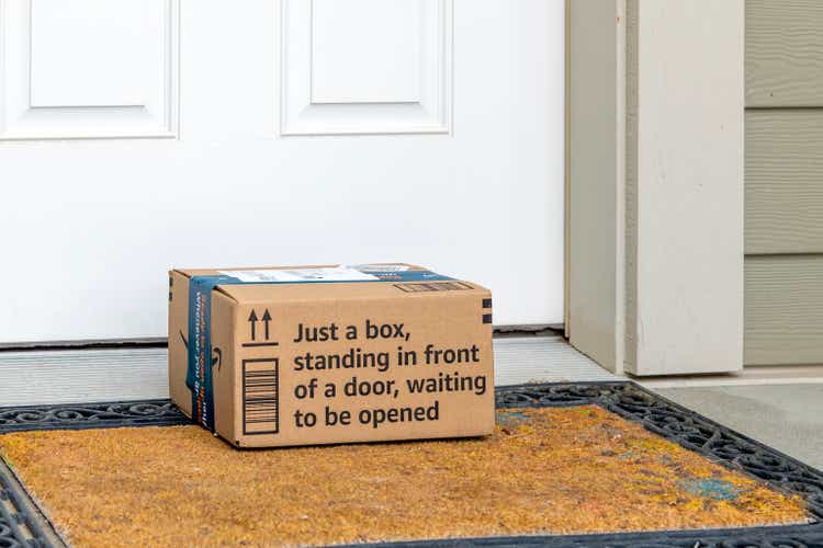 General view of an Amazon shipped cardboard box package with "just a box, standing in front of a door waiting to be opened" on the doorstep of a suburban home in Spokane, Washington