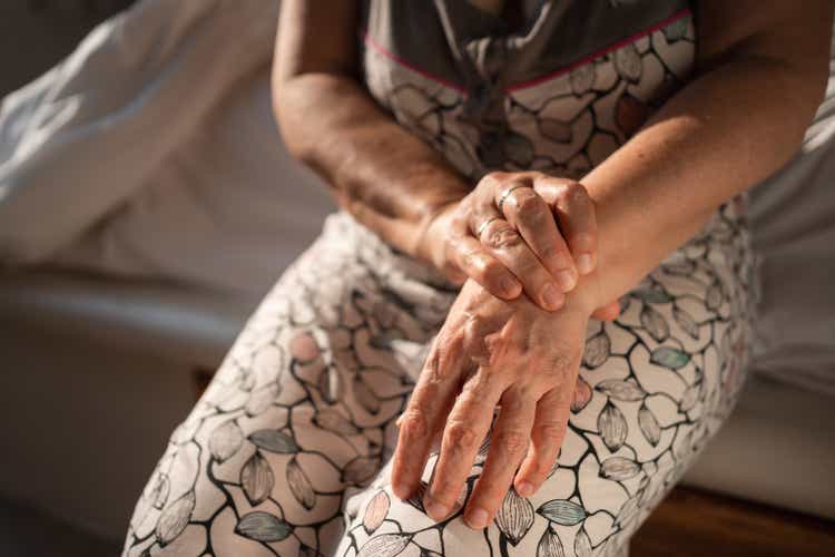 Senior woman tries self-massage to relieve the wrist pain