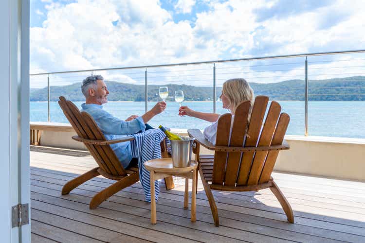 Mature couple drinking wine out on the deck.