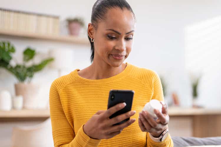 Woman searching pills instruction on smartphone