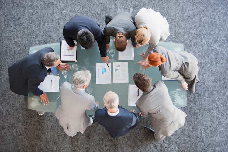 Business people huddled around paperwork on table