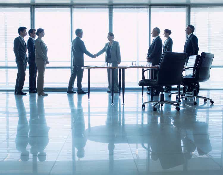 Business people shaking hands in conference room