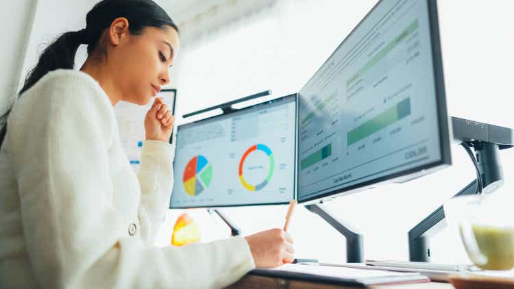 Woman with back pain working in home office at standing desk