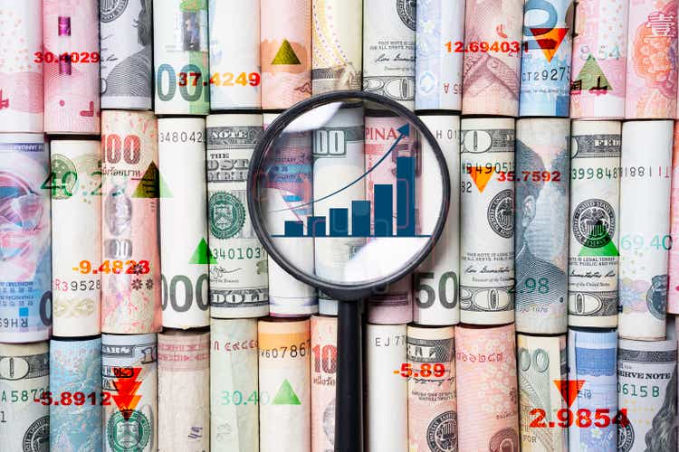 Top view of International banknotes rolls with magnifier glass and increasing graph for money transfer exchange and investment trade forex concept.