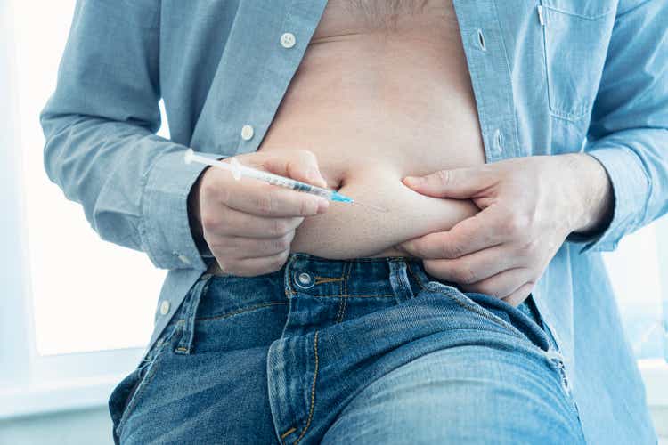 injecting insulin at home. young man hand using insulin syringe close up . self-medication