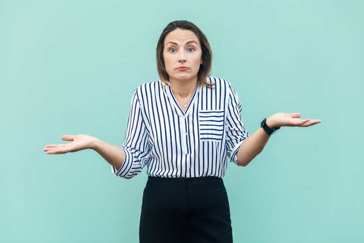 Uncertain clueless woman doesn"t know correct answer, looking at camera, shrugging shoulders.