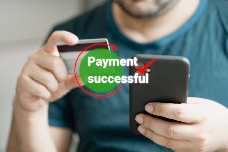 Man using smartphone and holding credit card with payment online successful screen.