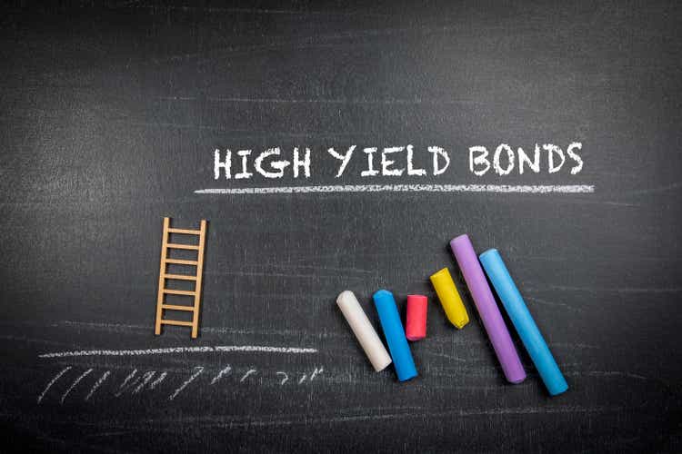 High yield bonds. Text and colored pieces of chalk on a dark board