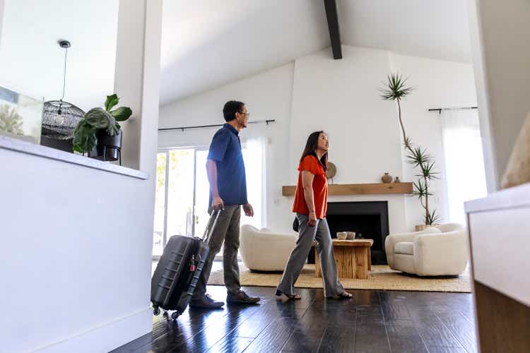 Side view of mature couple exploring living room of rental home