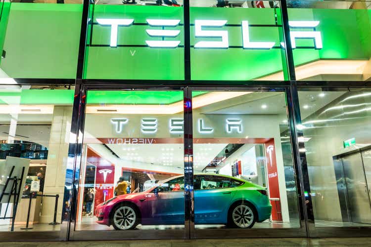 Tesla electric cars are on display in a shopping mall.