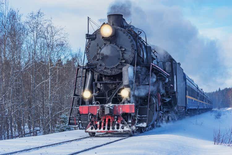 Retro steam train travels on a winter morning.