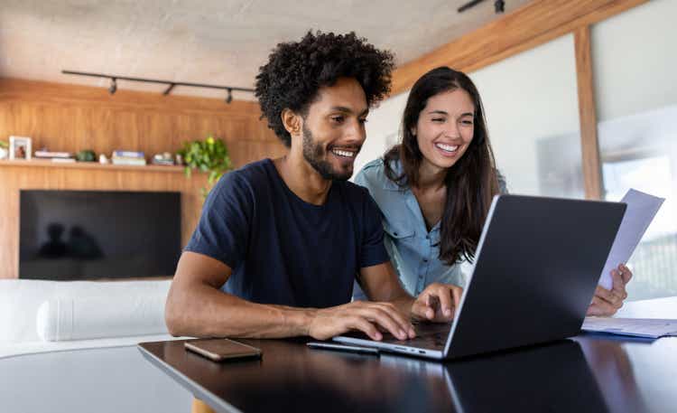 Young couple paying bills online using a laptop