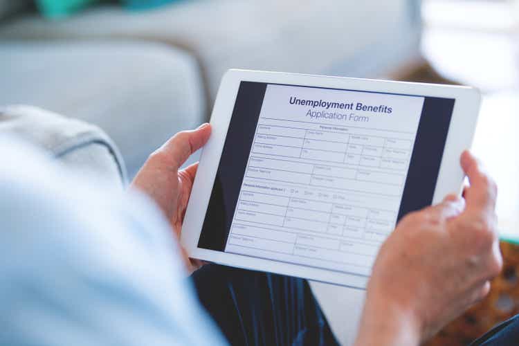 Man looking at an unemployment benefits form on a digital tablet.