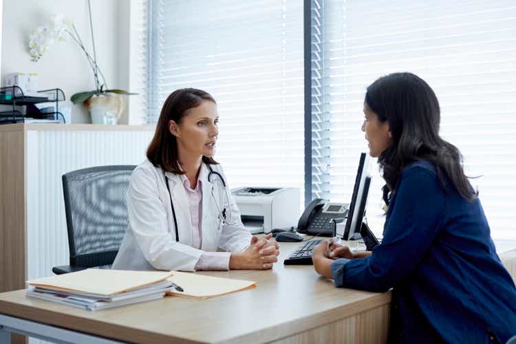 Doctor talking with female patient in clinic