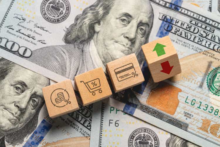 Inflation increase concept with icons showing inflation and price increases in wooden cubes on stack of dollars