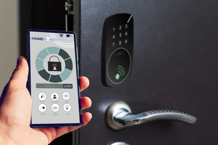 Locking smartlock on the entrance door using a smart phone remotely. Concept of using smart electronic locks with keyless access
