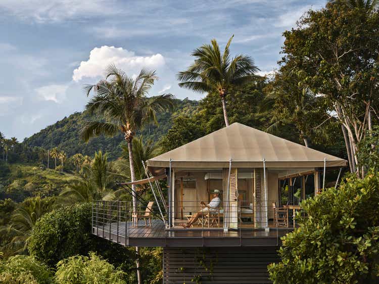 Male tourist admiring view while relaxing inside tented villa, at eco friendly, luxury Glamping resort.