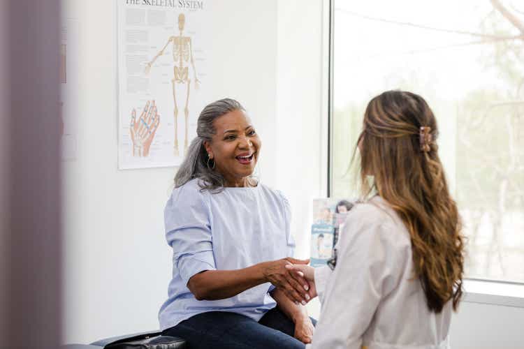 Female patient shaking hands with female medical professional