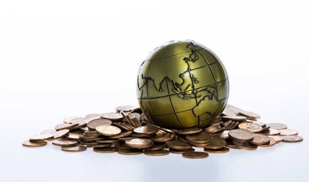 Metal globe on heap of coins