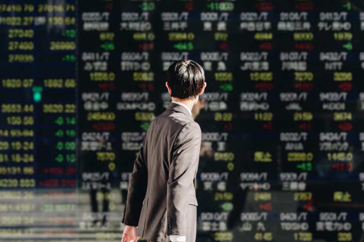 View the stock price board displayed on a business district electronic display board