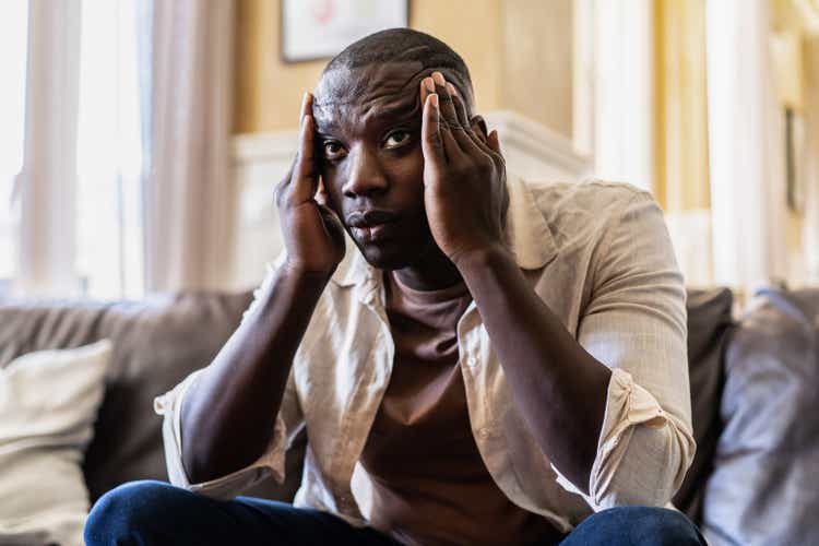 Shot of a young man looking stressed out at home