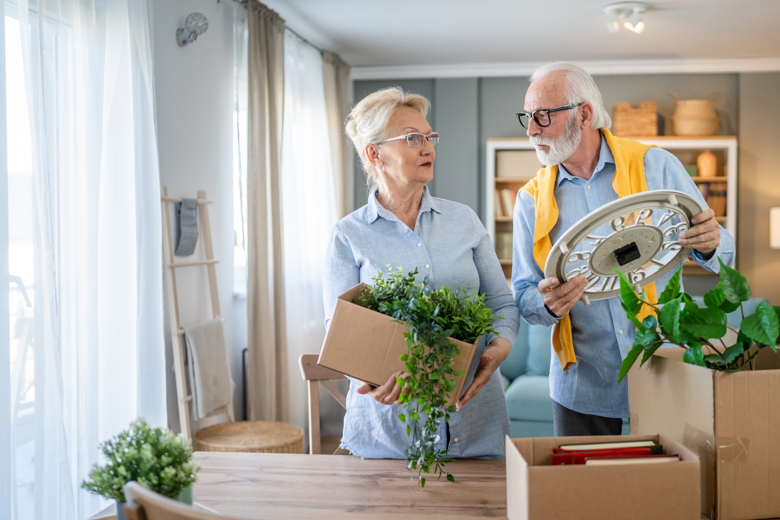 Senior couple man and woman husband wife pack or unpack boxes moving